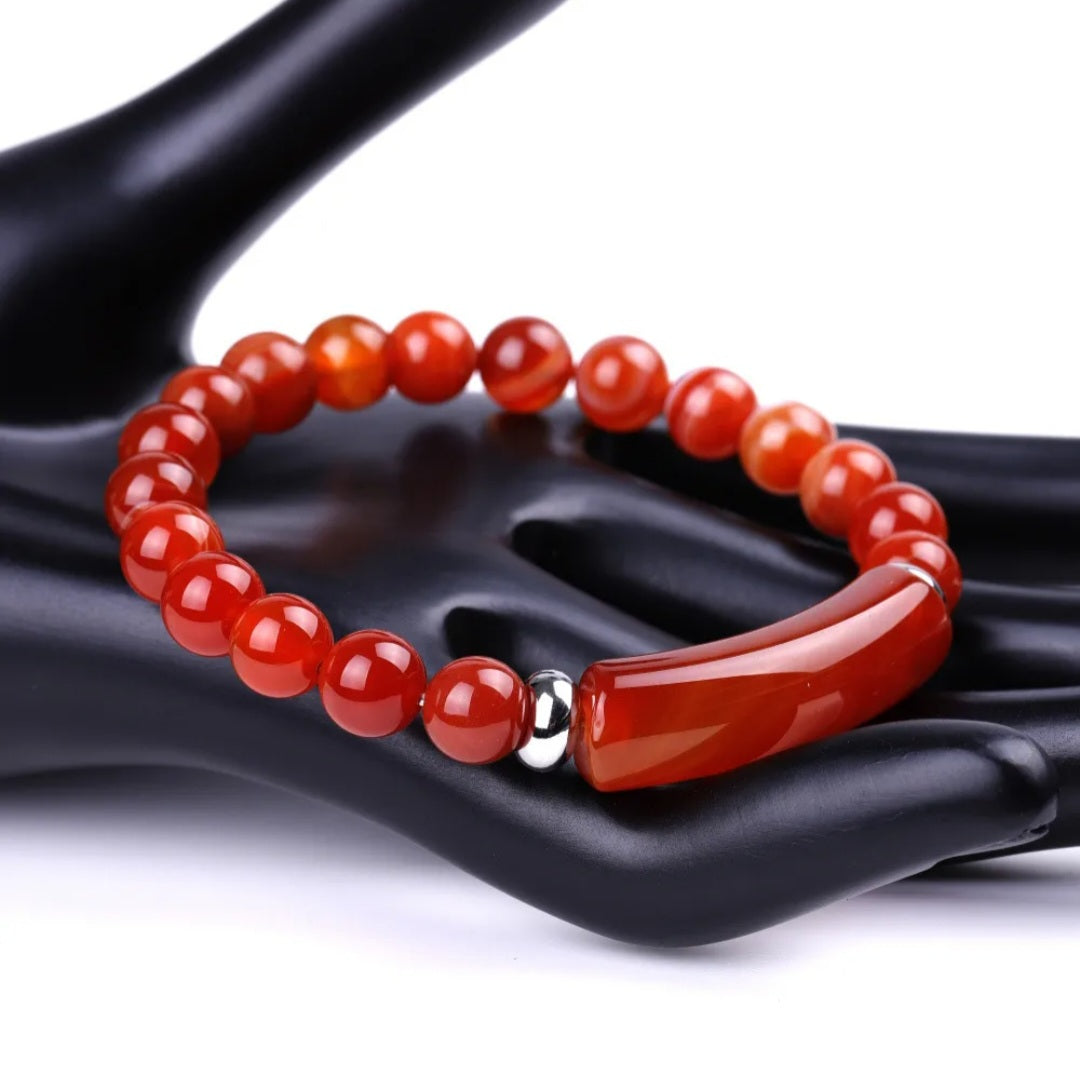 Red Carnelian beaded bracelet with a on a black hand-shaped stand.