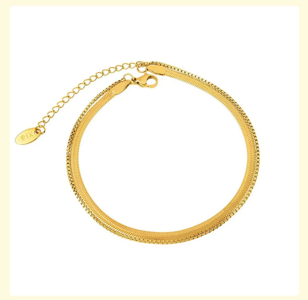 Gold anklet on a light beige background