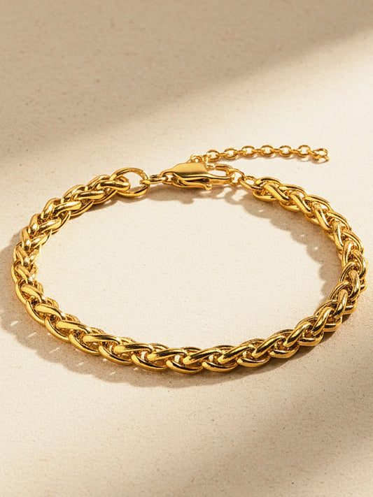 Gold chain bracelet on a beige background