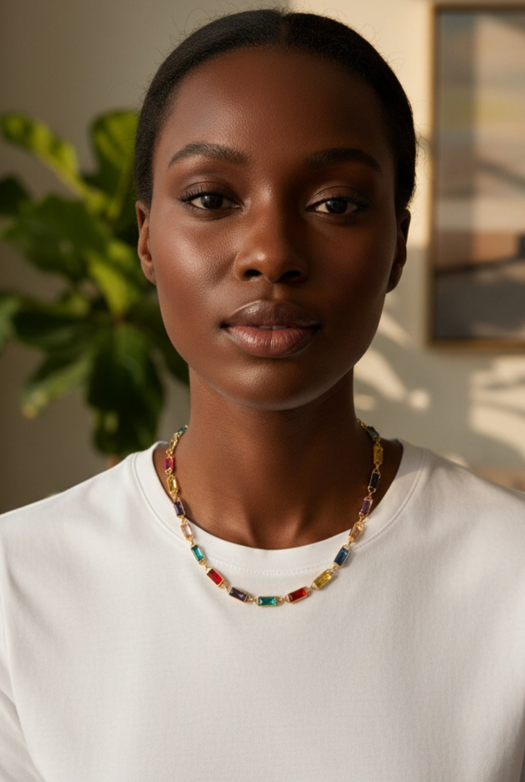 Woman wearing a colorful necklace indoors with a plant in the background