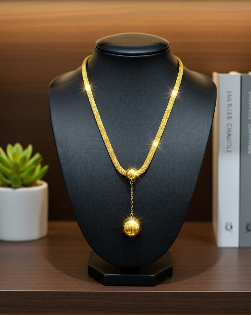 Gold necklace on a black mannequin bust with a blurred background