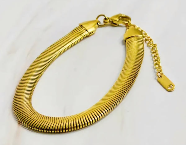 Gold herringbone bracelet on a white background.