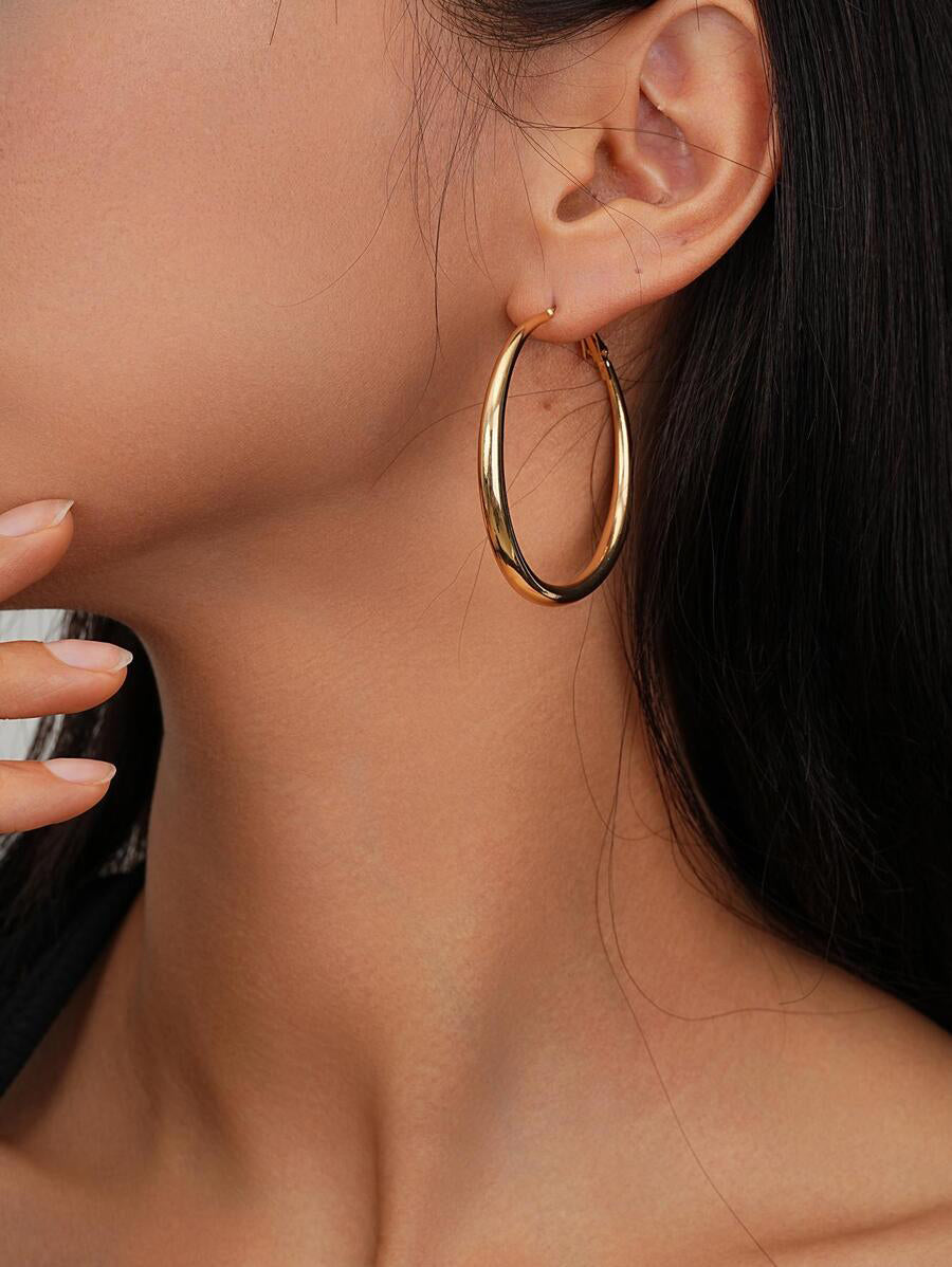 Gold hoop earring worn by a person