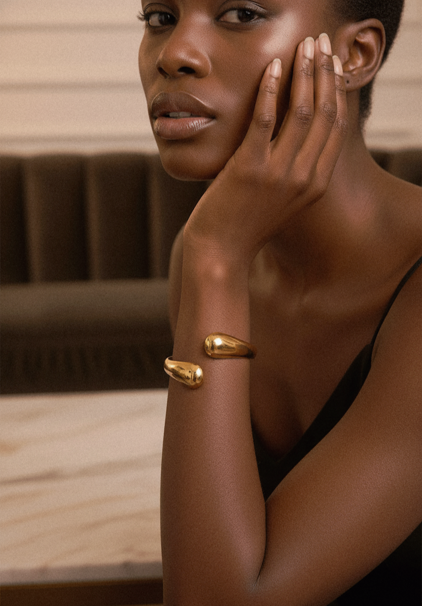 Woman wearing a gold bracelet with a blurred background