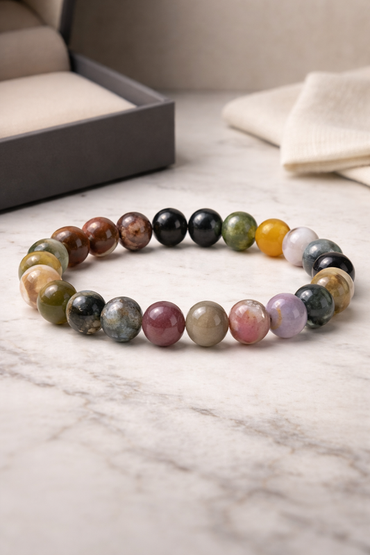 Multicolored crystal stone beaded bracelet on a marble surface with a neutral background