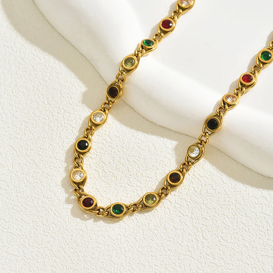 Gold necklace with multi-color cubic zirconia crystals on a white background
