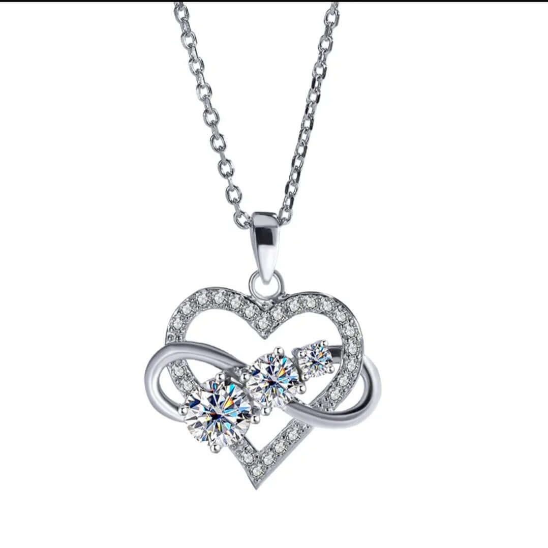 Silver necklace with heart-shaped pendant with sparkling Moissanite stones on a white background. 