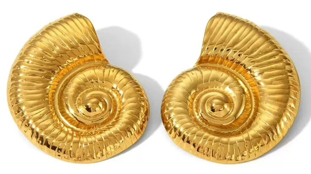 A pair of gold nautilus shell shaped earrings on a white background.
