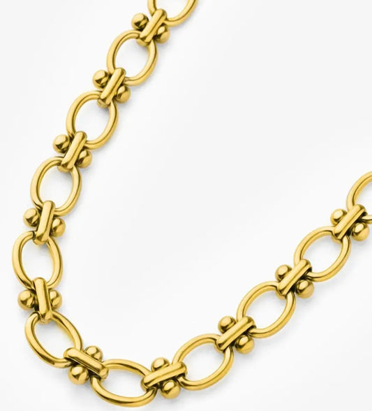 Gold necklace with rounded ball and loop on white backgroud. 