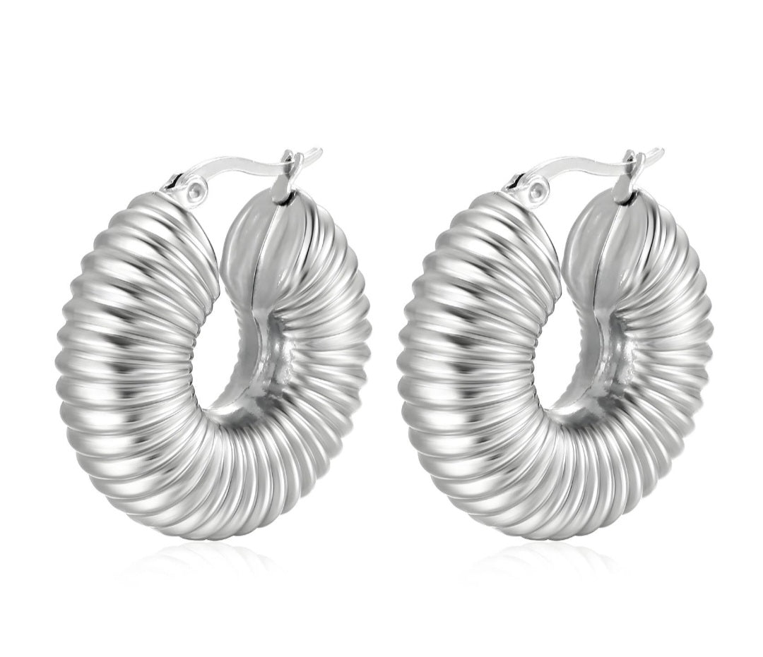 Silver hoop earrings with a ribbed texture on a white background